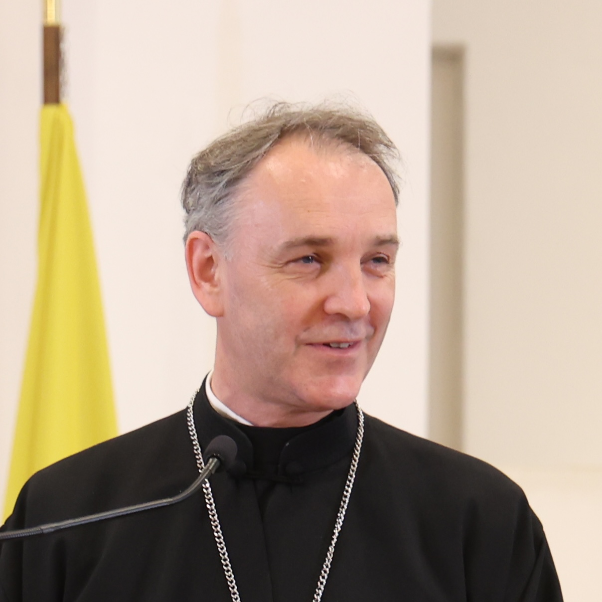 Juraj Mistina speaking at a microphone