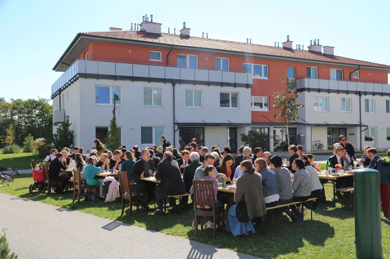 Community feast at long tables between the campus residences