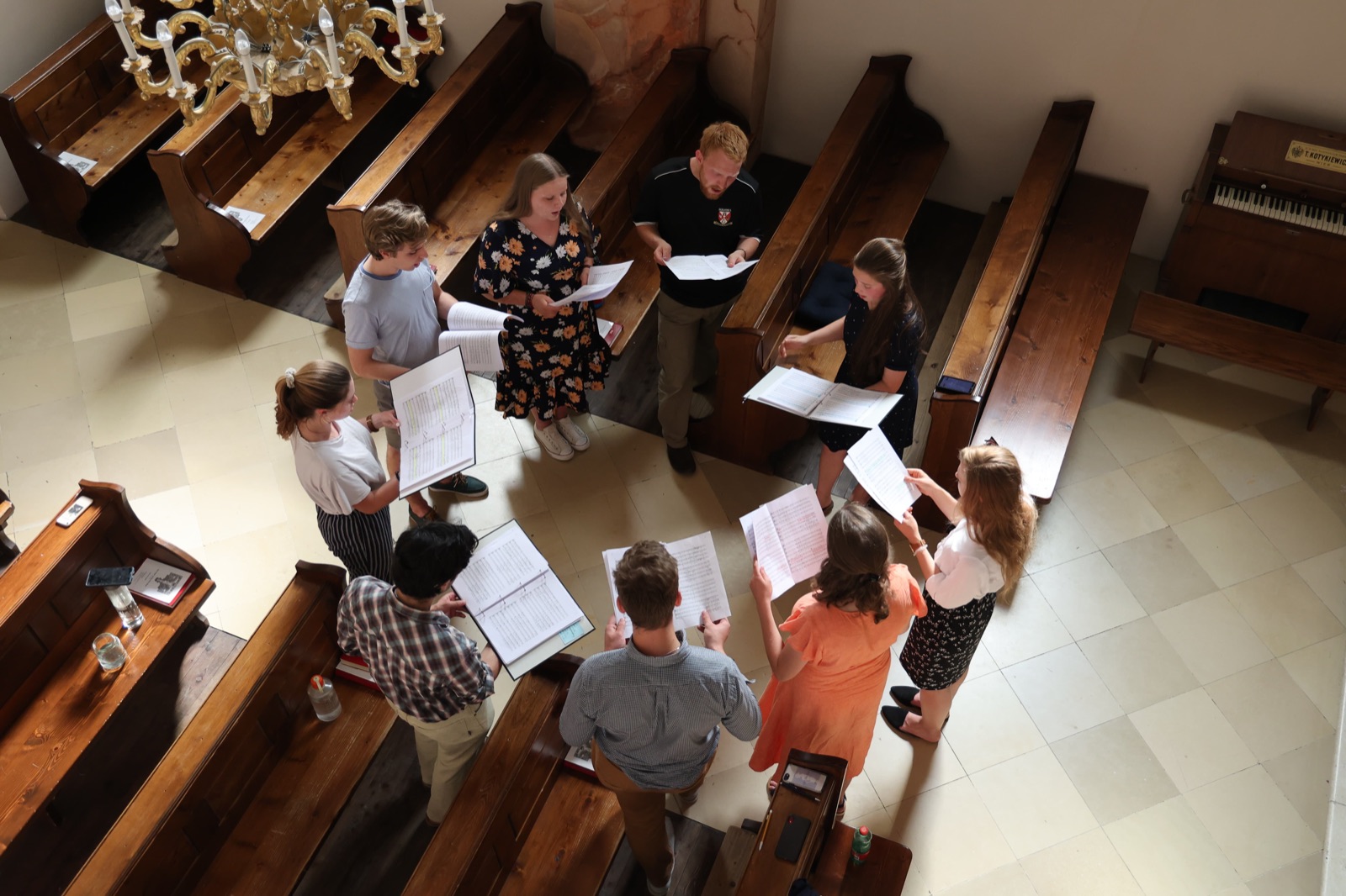 Choir rehearsing in a circle, seen from the church gallery