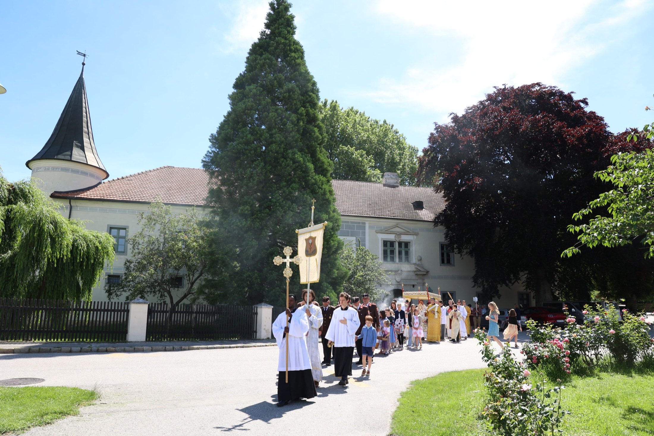 Corpus Christi procession with cross and banners in front of Schloss Trumau