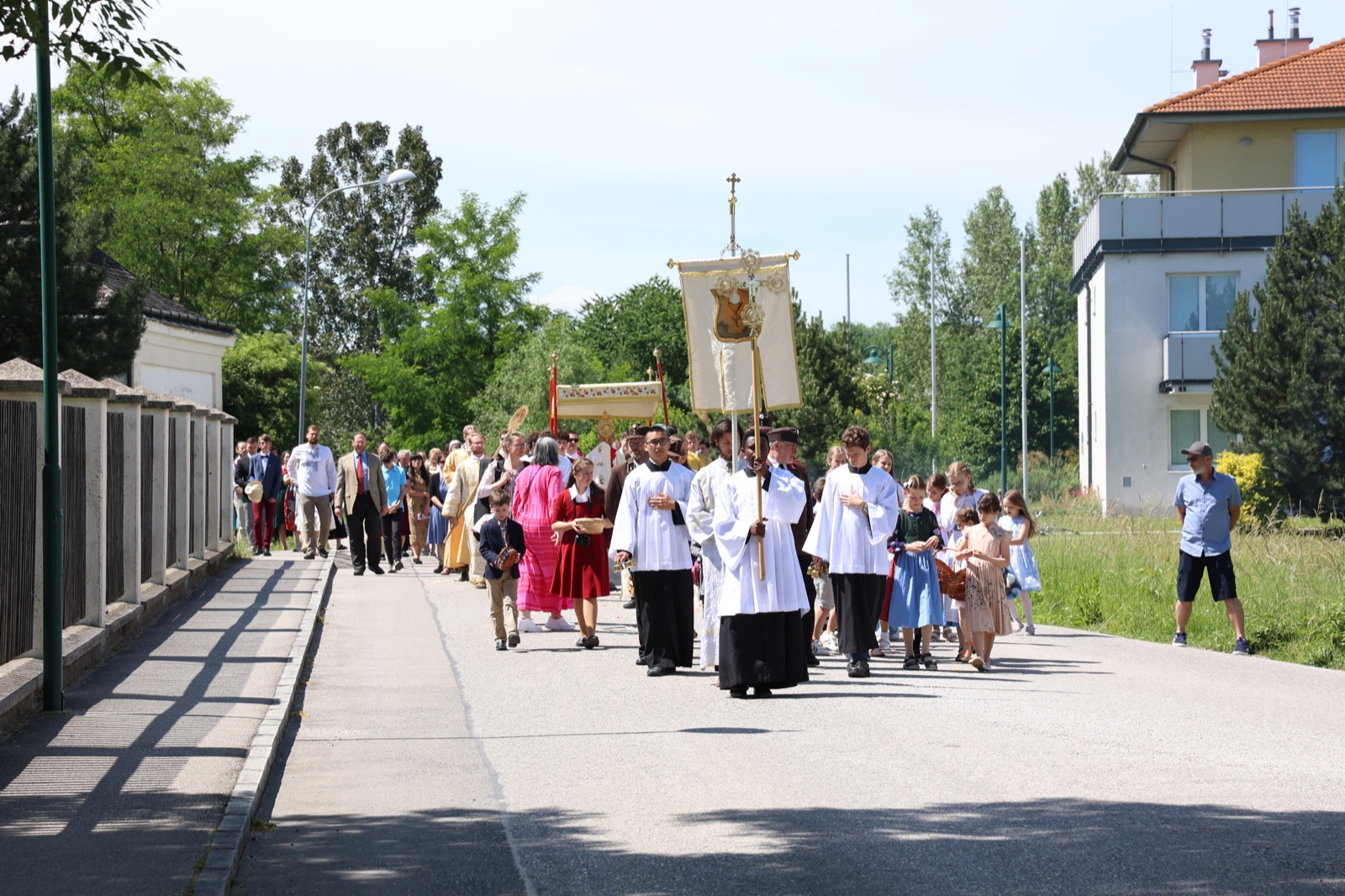 Corpus Christi procession with canopy and families through Trumau