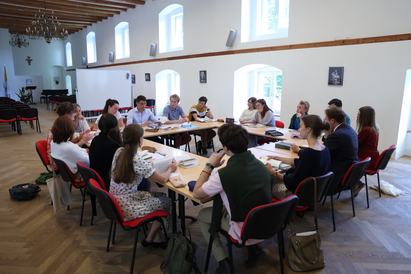 Large seminar circle of students under a chandelier